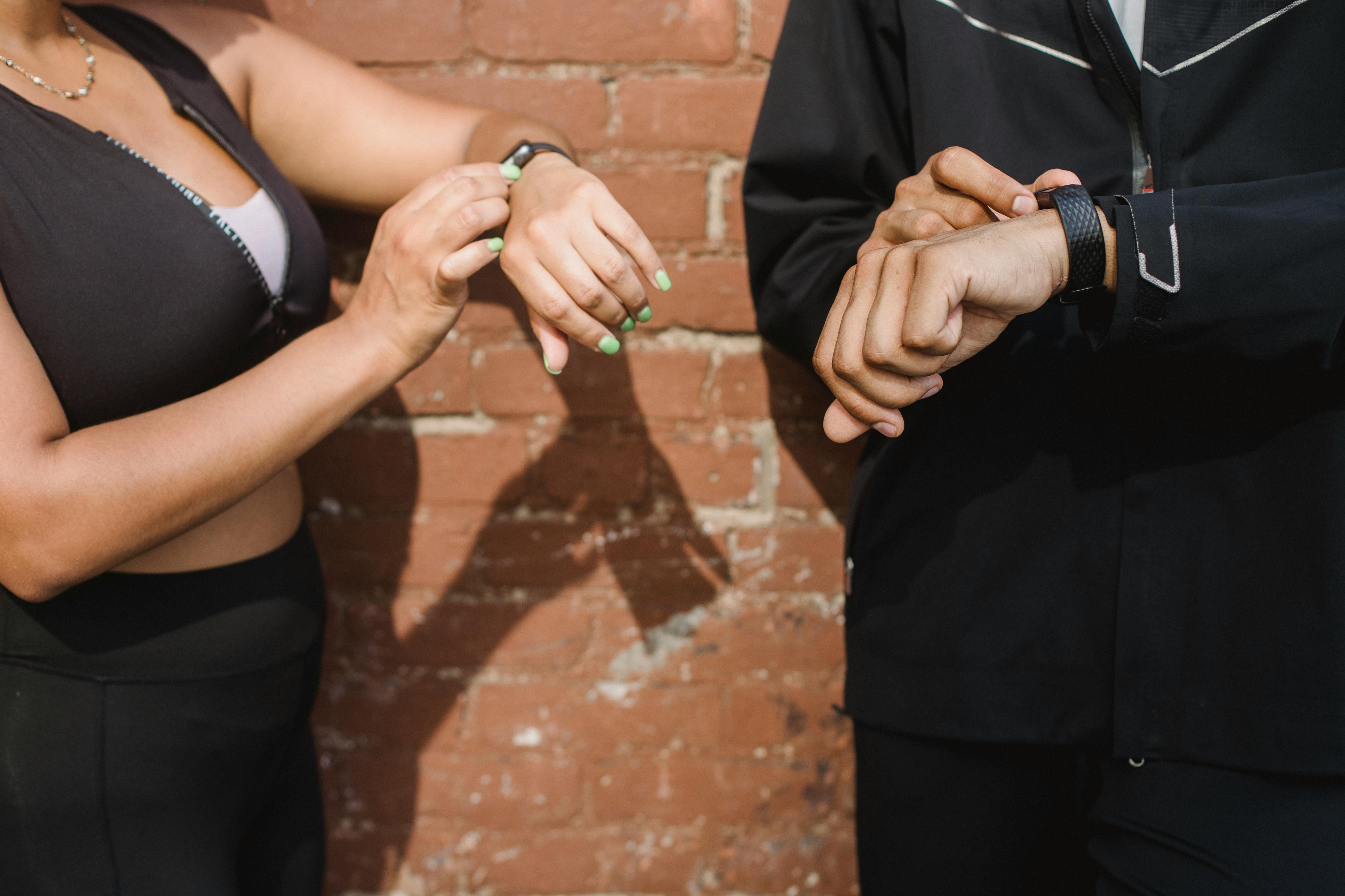 Man and woman wearing smartwatches | Source: Pexels