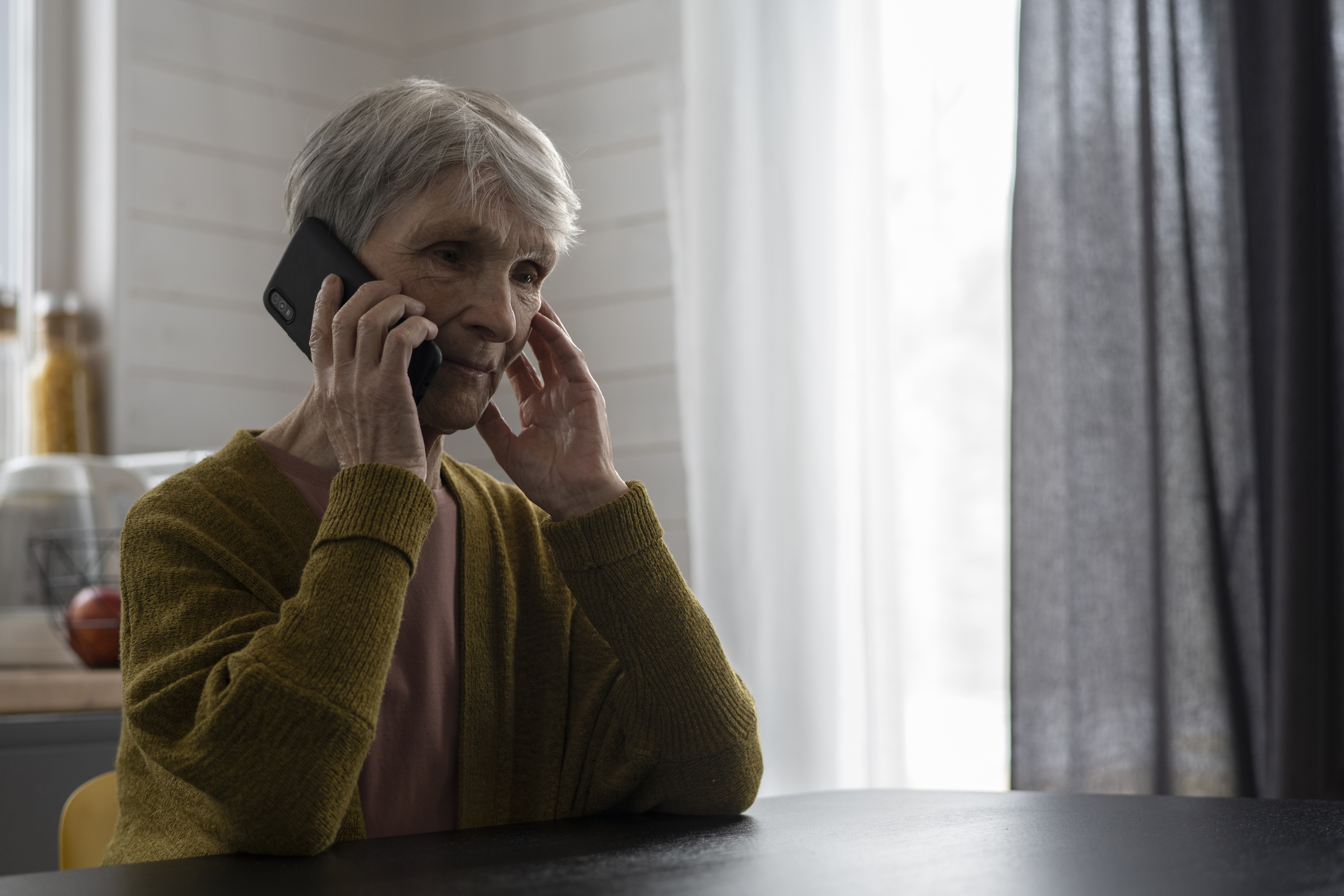 An elderly woman looking worried while on the phone | Source: Freepik